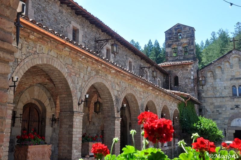 Castello Di Amorosa: каменные арки и красные герани в солнечном дворе